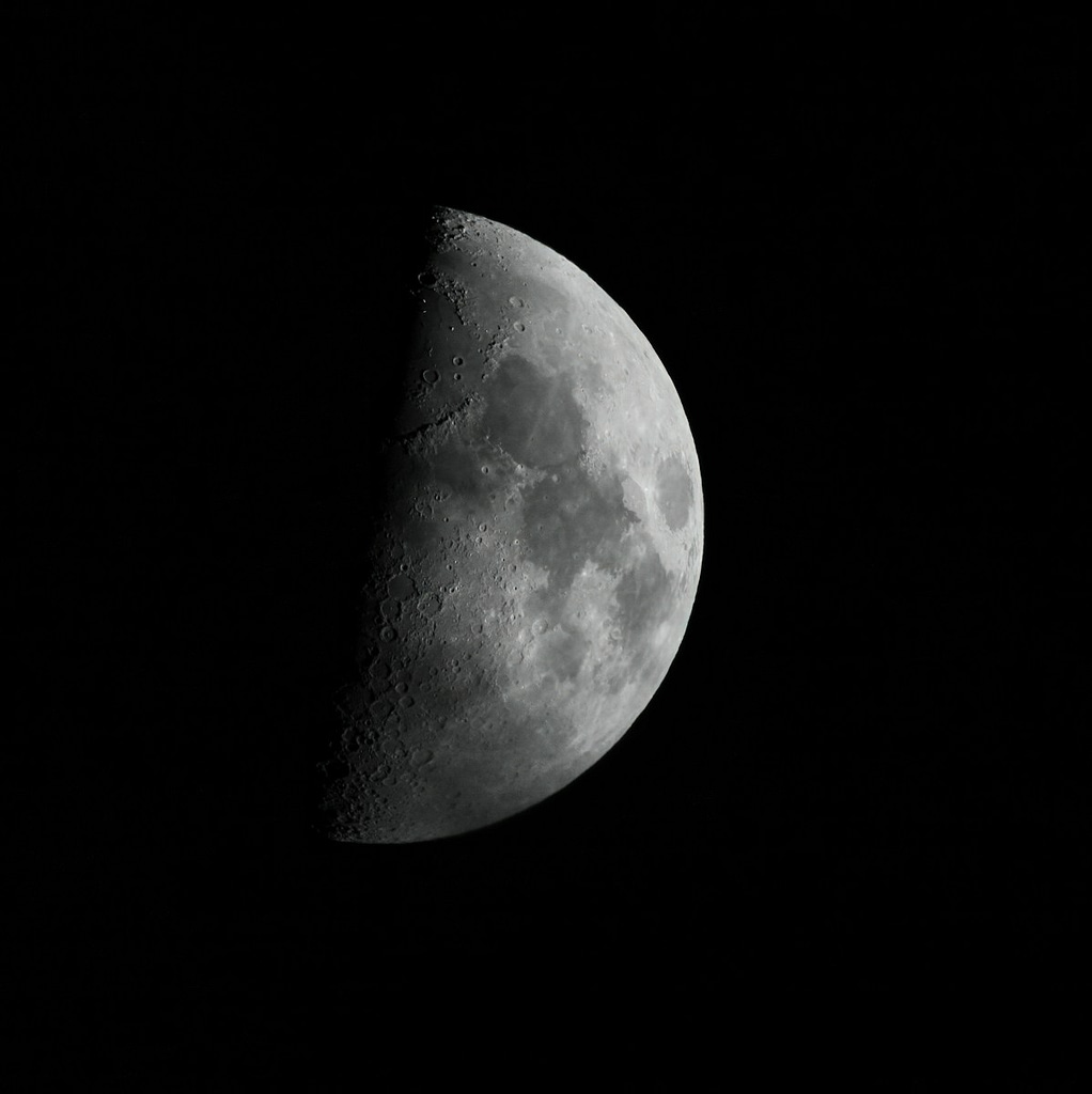 a first quarter moon is shown in the dark sky
