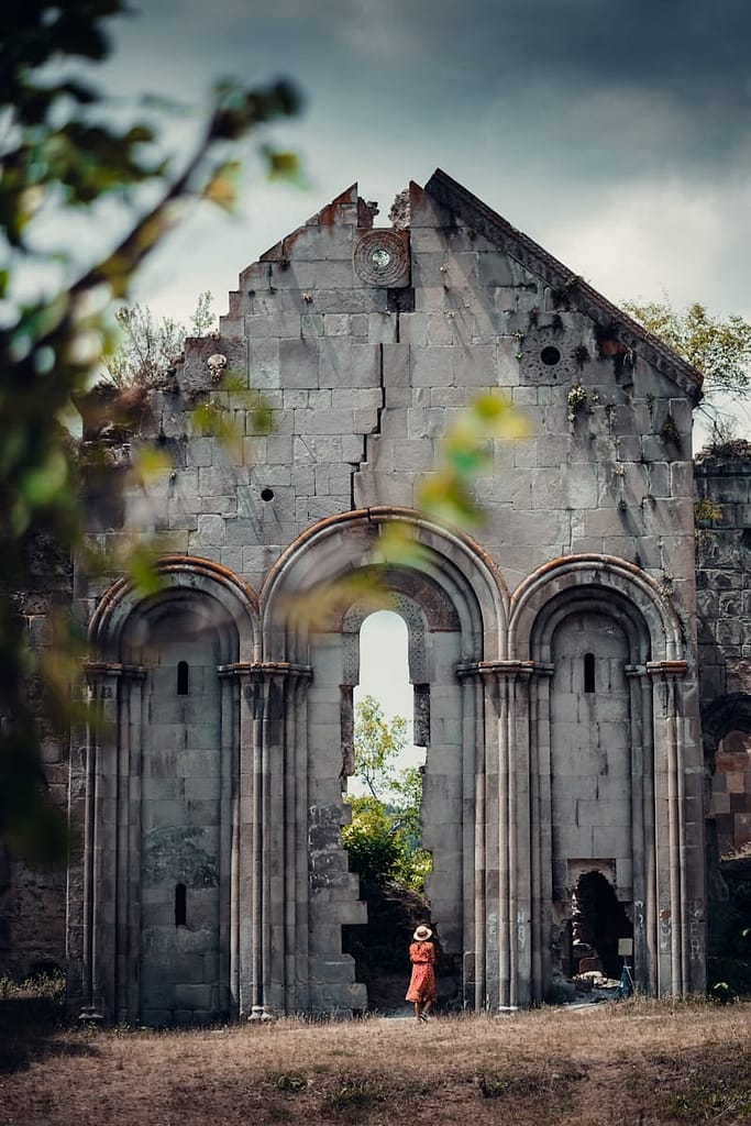 a child standing in front of a broken church