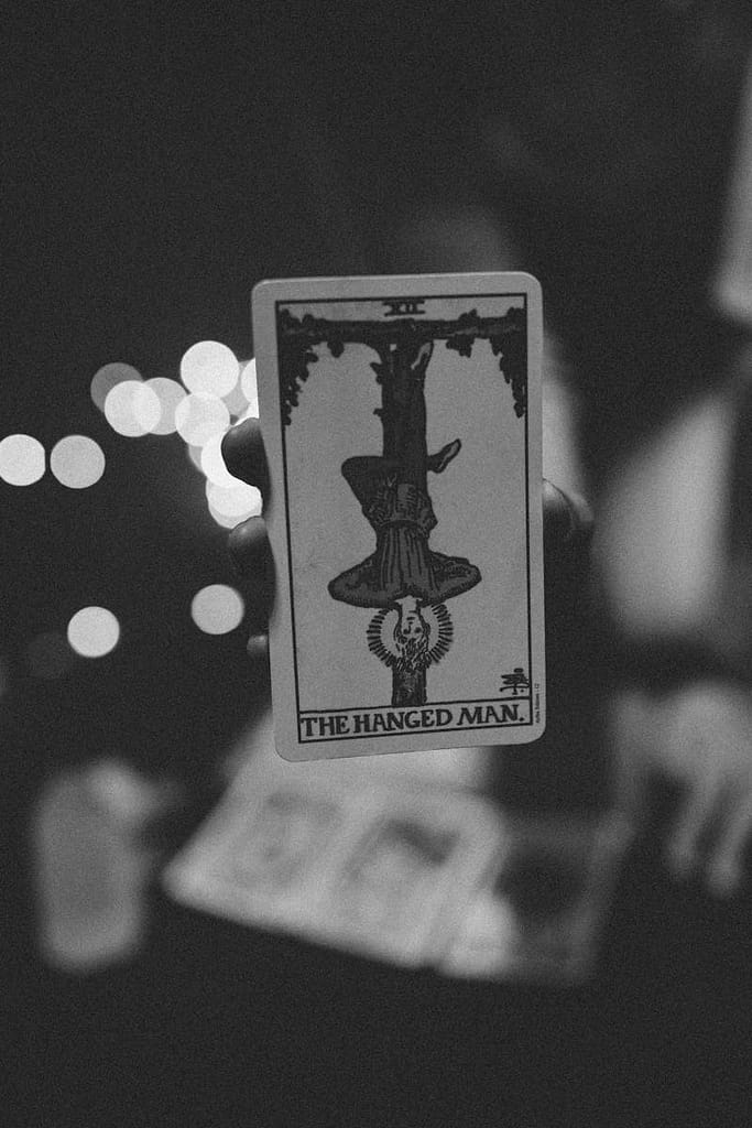 Artistic black and white photo of a tarot card with bokeh lights, perfect for mystical themes.