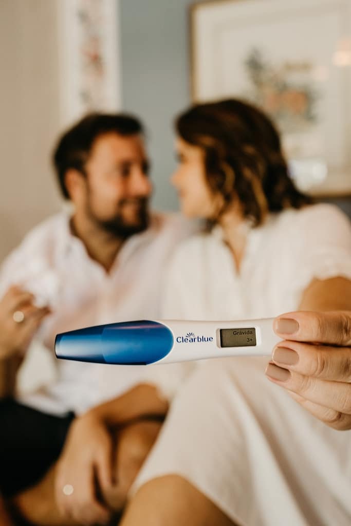 man in white dress shirt holding blue and white pregnancy test