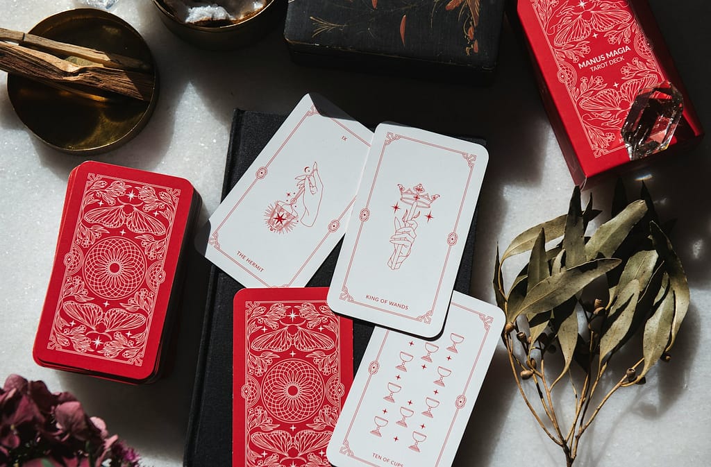 Tarot Basics: Your #1 Ultimate Guide To Unlock Tarot Success A table topped with lots of red and white tarot cards