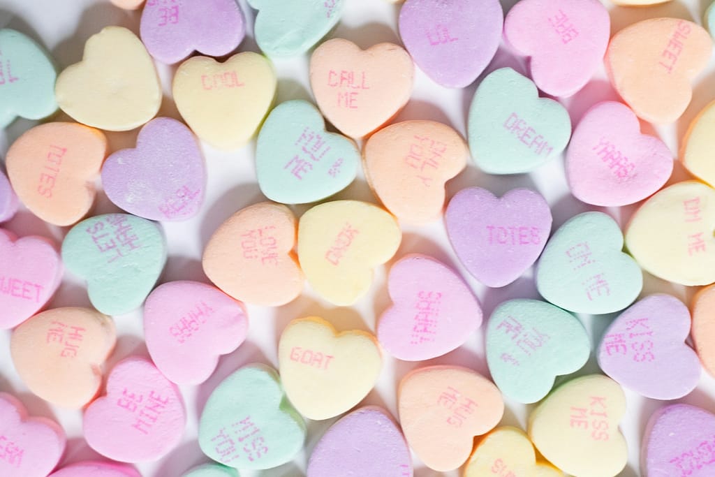 The Perfect Valentine'S Tarot Reading For Your Love Life A pile of conversation hearts on a white surface