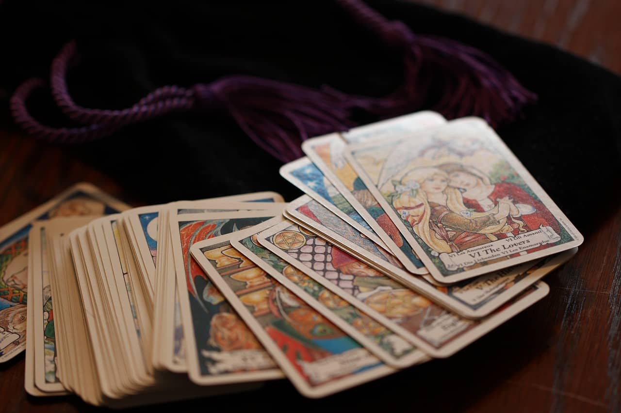 Tarot cards spread out beside a velvet pouch, introducing the theme of how tarot can help you check in with yourself through the four suits of the Minor Arcana.