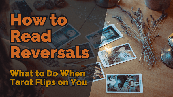 A tarot reading setup on a wooden table with reversed tarot cards scattered. A hand with tattooed fingers rests near the cards, and dried lavender lies beside them. The image has bold text overlay reading “how to read reversals: what to do when tarot flips on you. ”