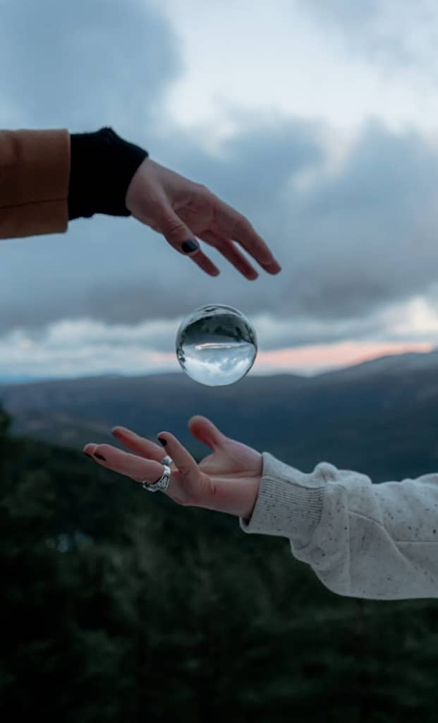 7 Brutally Honest Tips Before Your First Tarot Reading Person holding clear glass ball