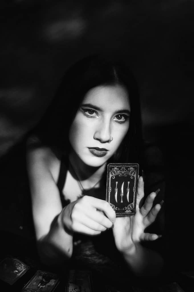 Is Tarot Evil? What The Bible Says About Tarot Cards A black and white photo of a woman holding a tarot card