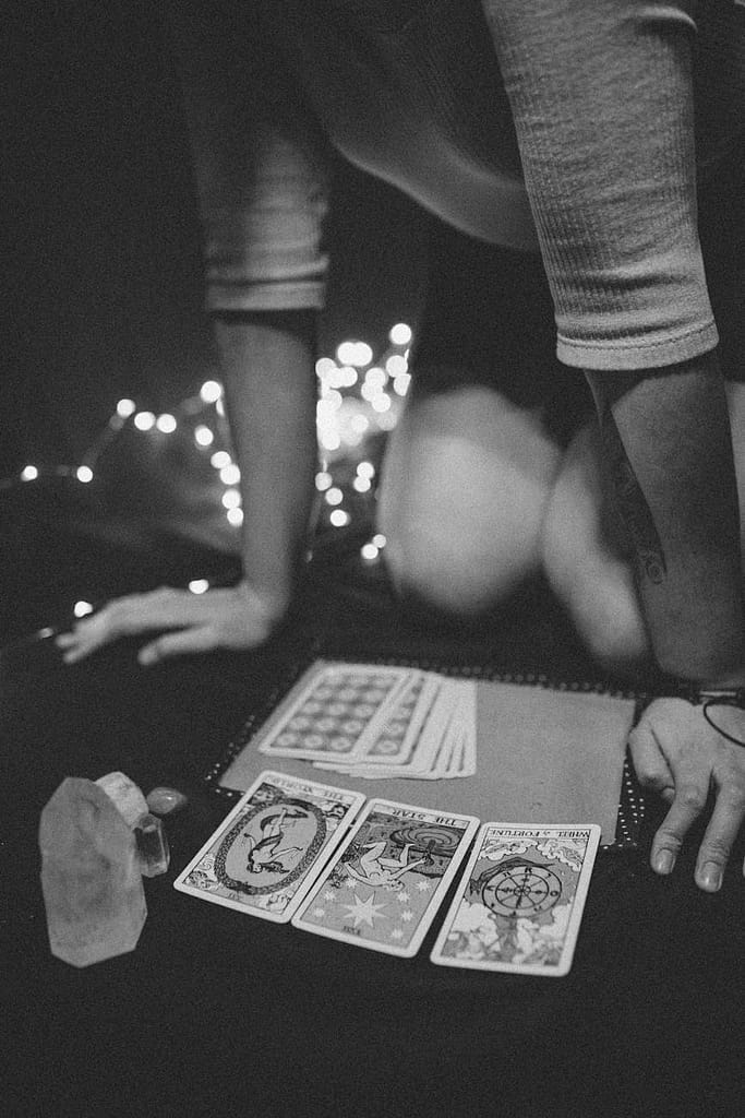 How The Enneagram Helped Me Understand Myself (Eventually) 5 Tarot cards, crystals, and a journal laid out on a table, illustrating practices that support enneagram self-awareness and emotional grounding.