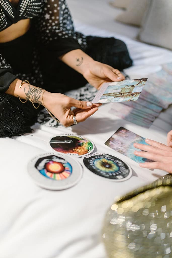 Learn Tarot in Manchester: Simply Tarot Course 4 Two people engaging in a tarot card reading session with colorful cards and spiritual symbols.