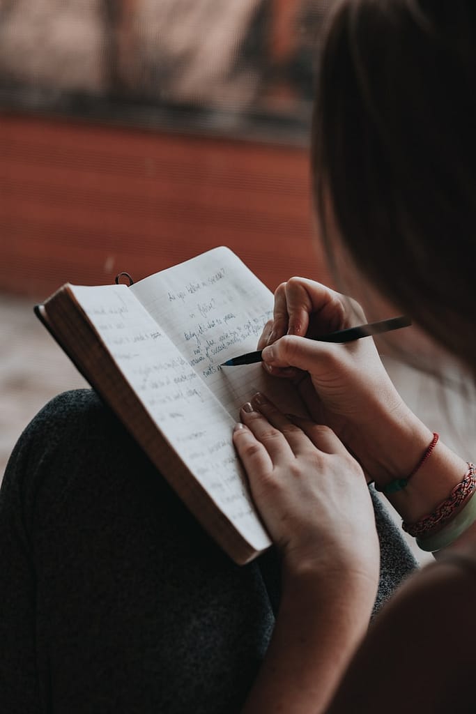 Explore Tarot, Journalling and Meditation in Manchester 3 Person journalling in a notebook with focus and intention, illustrating the practice of tarot, journalling and meditation in Manchester.