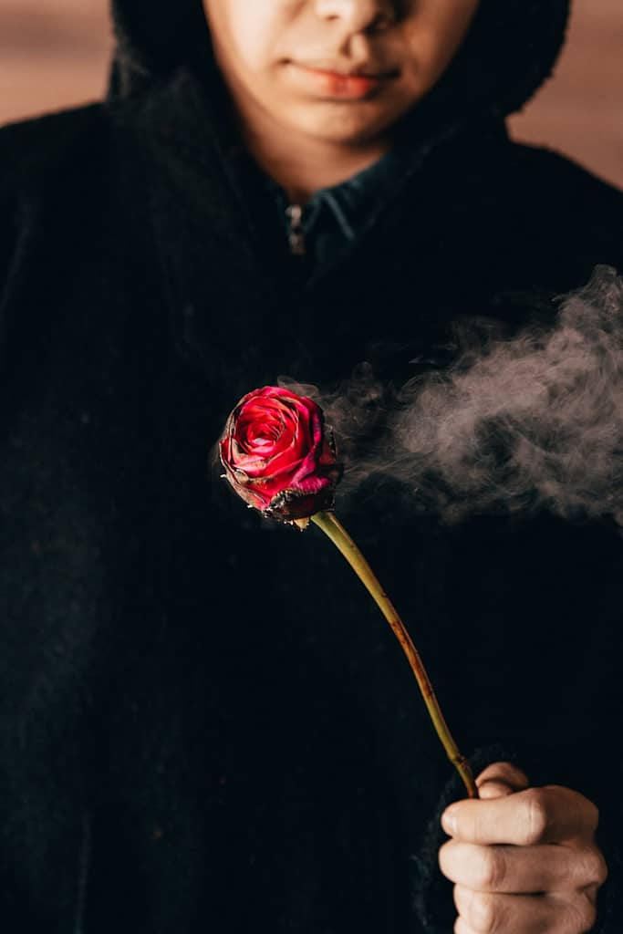 The One Question That Can Transform Any Tarot Reading Person in black shirt holding red rose