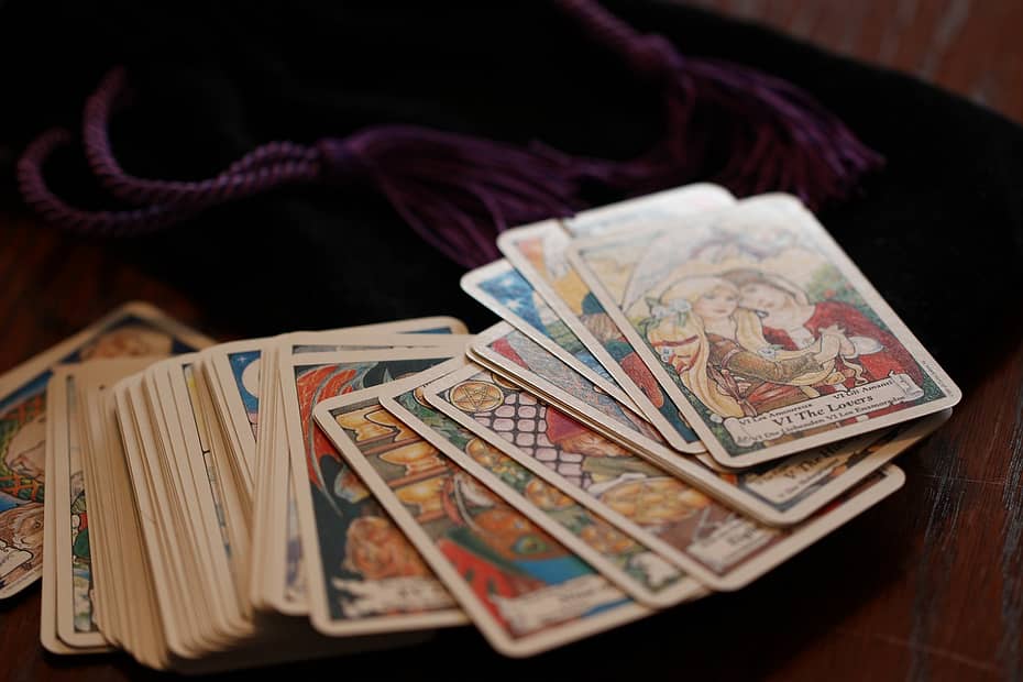 Tarot cards spread out beside a velvet pouch, introducing the theme of how tarot can help you check in with yourself through the four suits of the Minor Arcana.