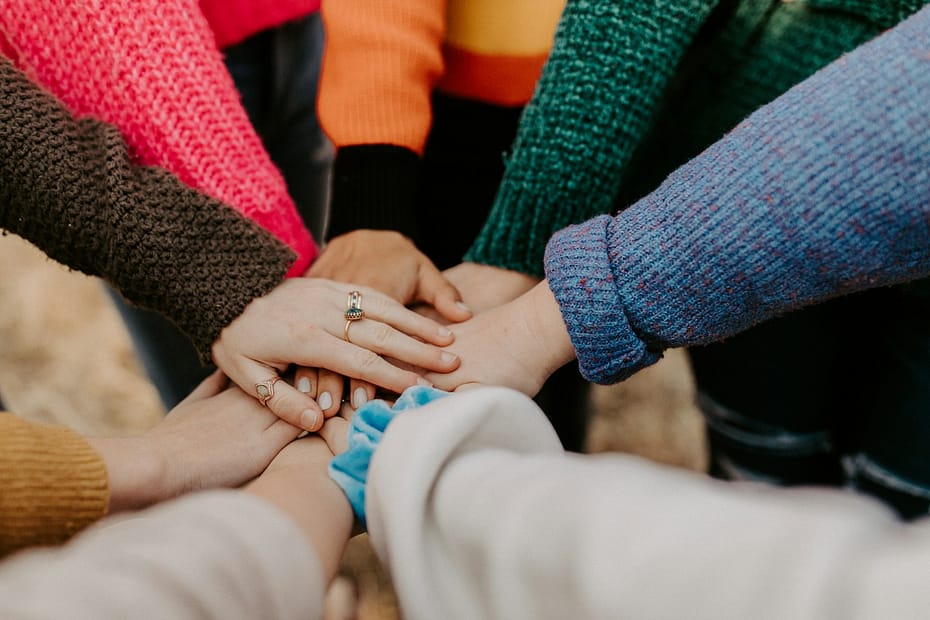 The Power of Coming Together in Ceremony 1 person in red sweater holding babys hand